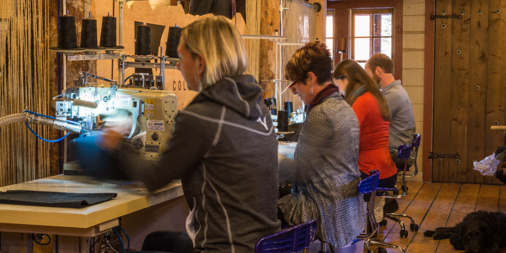 workers sewing garments with their back to the camera