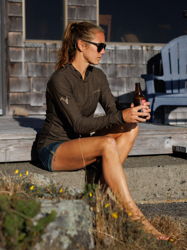 Woman wearing VOORMI holding a drink on a deck