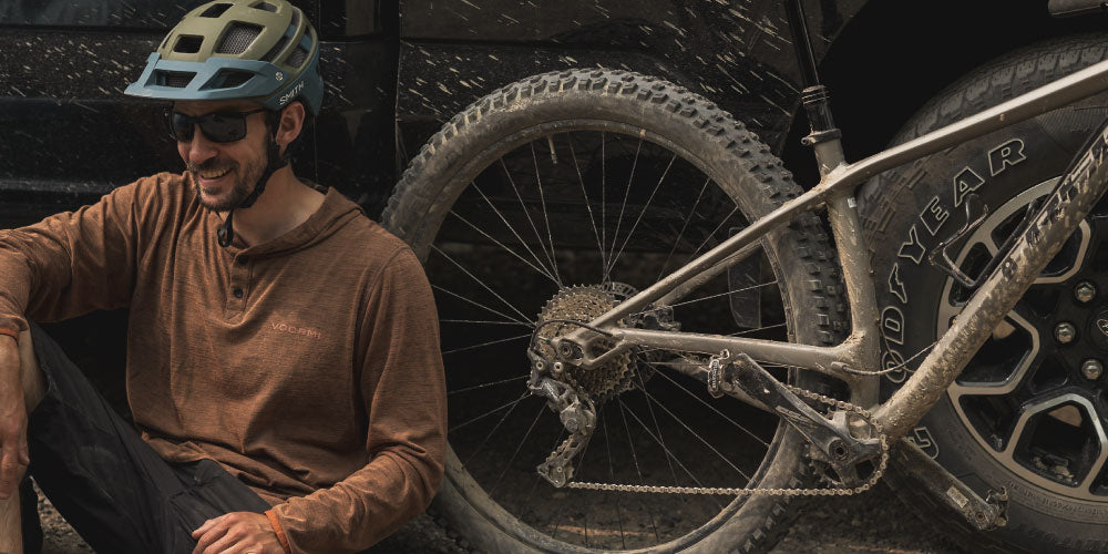 Man sitting next to truck after riding their bike.